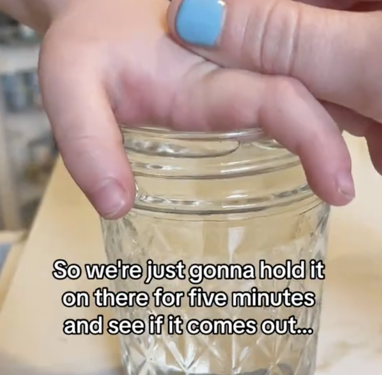 child's hand over mason jar filled with hot water